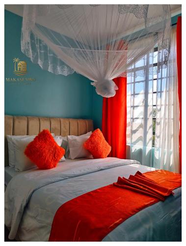 a bed with red and white pillows and a window at Makasembo breeze homes in Kisumu