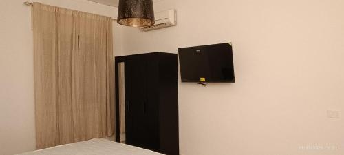 una camera da letto con una TV a schermo piatto sul muro di Happy House Herculaneum a Ercolano