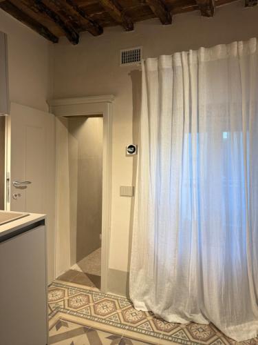 una cucina con una tenda bianca sul muro di BORGO COMPAGNIA Porta Fredda a Castiglion Fibocchi