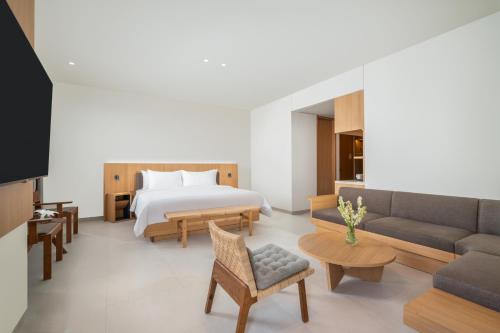 een hotelkamer met een bed en een bank bij ARTOTEL Leguna Magelang in Magelang