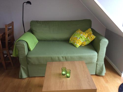 a green couch in a living room with a coffee table at Ljungs Fem Rum in Västergarn
