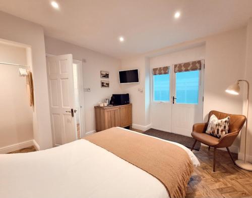 een slaapkamer met een bed, een stoel en een televisie bij The Mews Room at The Coach House in Windermere