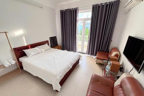 una camera da letto con un letto, un divano e una televisione di Phòng ngủ riêng khép kín a Nha Trang