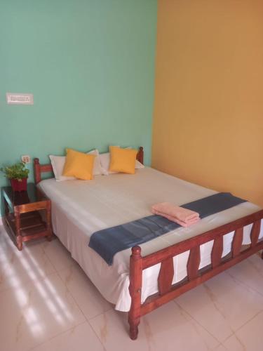 a bedroom with a bed with orange and blue pillows at Stay by Asharaf AS Villa in Varkala