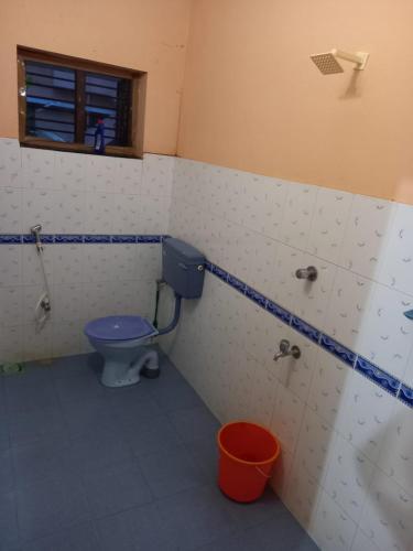 a bathroom with a blue toilet and a window at Stay by Asharaf AS Villa in Varkala