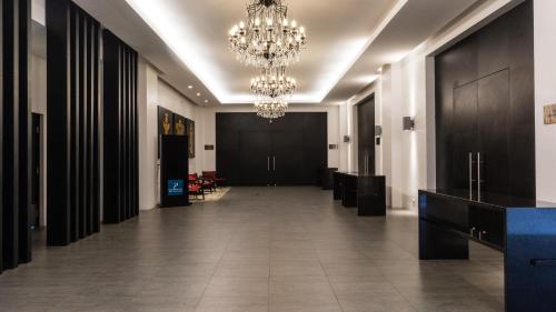 a hallway with a chandelier and a long corridor at Hotel Antofagasta in Antofagasta