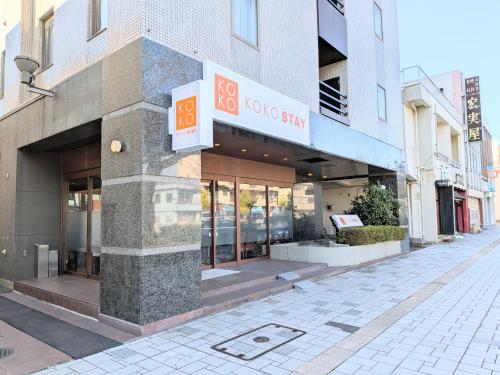 a store with a sign on the side of a street at KOKO STAY Hitachi- formerly Hotel Wing International Hitachi in Hitachi