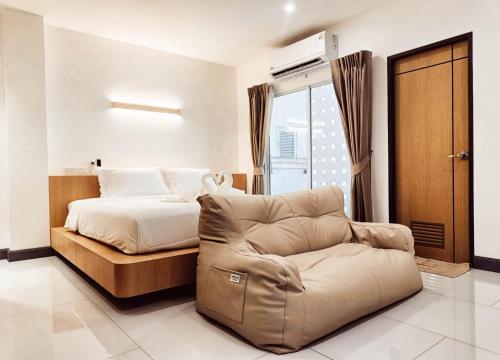 una camera da letto con un letto, un divano e una sedia di Laksika Place Khao Rang a Phuket
