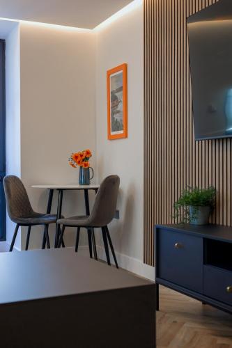 a dining room with a table and a tv at Old Kirk Apartment in Oban