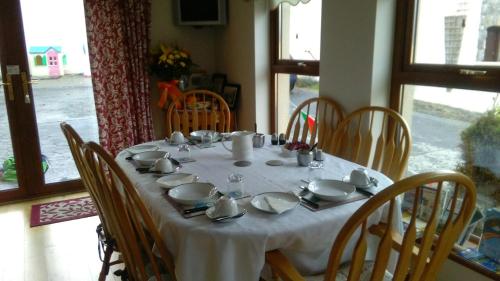 a dining room table with a white table cloth and chairs at Hillcrest B&B in Westport