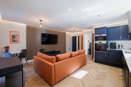 a living room with a couch and a kitchen at Old Kirk Apartment in Oban