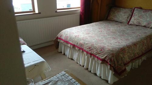 a bedroom with a bed and two windows at Hillcrest B&B in Westport