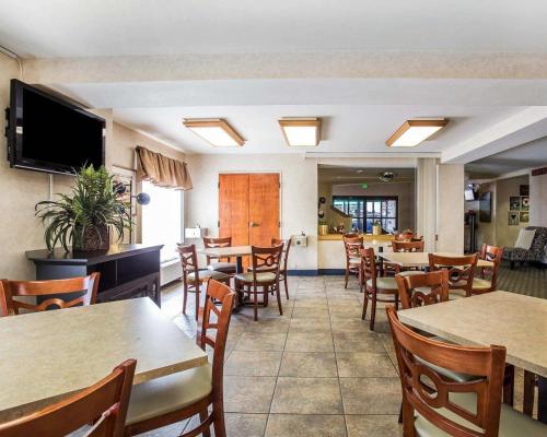 a restaurant with tables and chairs and a television at Econo Lodge Denver International Airport in Aurora