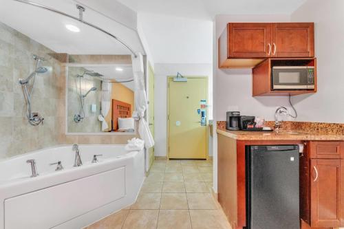 a bathroom with a tub and a sink and a bath tub at Rodeway Inn & Suites Fort Lauderdale Airport & Cruise Port in Fort Lauderdale