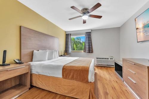 a bedroom with a bed and a ceiling fan at Rodeway Inn & Suites Fort Lauderdale Airport & Cruise Port in Fort Lauderdale