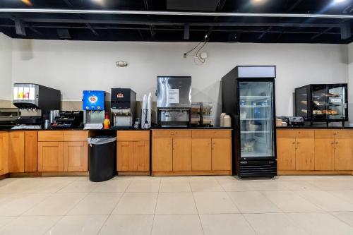 a kitchen with wooden cabinets and a refrigerator at Rodeway Inn & Suites Fort Lauderdale Airport & Cruise Port in Fort Lauderdale