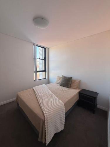 a bedroom with a bed with a blanket on it at The Modern 2B APT Rosebery in Sydney