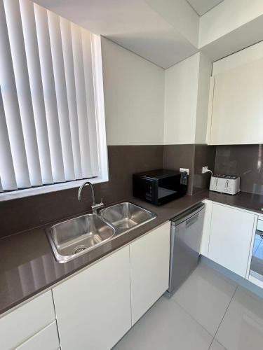 a kitchen with a sink and a microwave at The Modern 2B APT Rosebery in Sydney