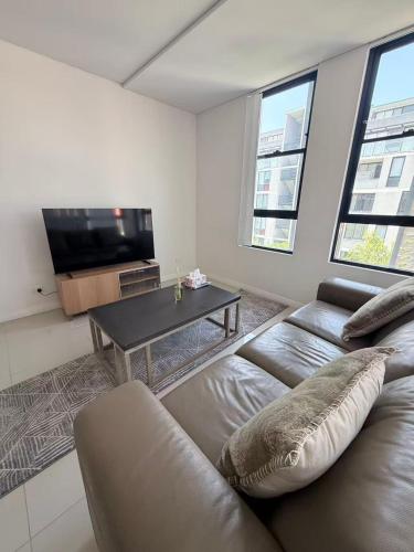 a living room with a couch and a table at The Modern 2B APT Rosebery in Sydney