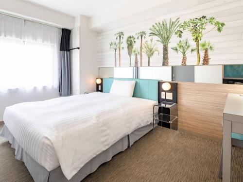 a bedroom with a large bed and a desk at Comfort Inn Naha Tomari Port in Naha