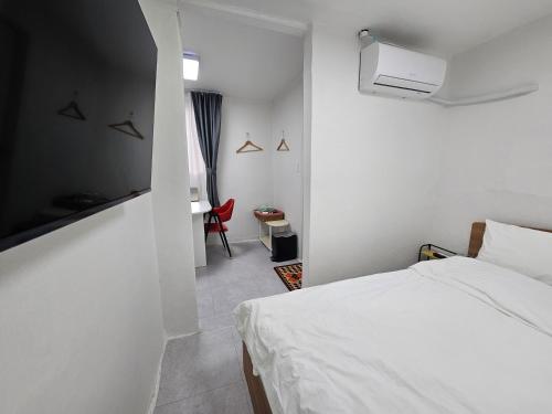 a bedroom with a bed and a tv on the wall at 목포 달달마실 게스트하우스 in Mokpo