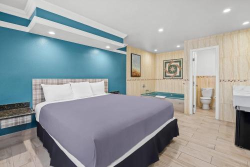 una camera da letto con un letto grande e un bagno di Rodeway Inn Commerce - Los Angeles a Commerce