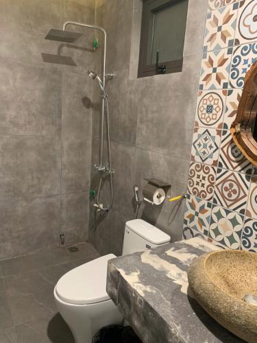 a bathroom with a toilet and a shower and a sink at MD Hotel in Mỹ Lộc