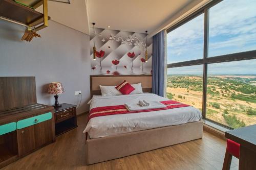 a bedroom with a bed and a large window at APEC Mandala Mũi Né VIP in Mui Ne