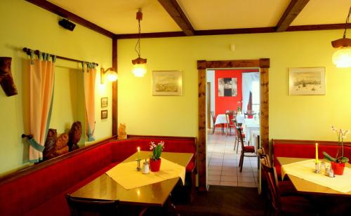 a restaurant with two tables and a red couch at Hotel Brockenstübchen in Schierke