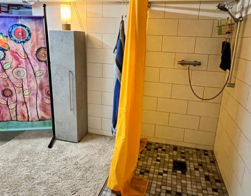 eine Dusche mit gelbem Vorhang im Bad in der Unterkunft Kleine Landhaus-Perle am Schlosspark in Eutin