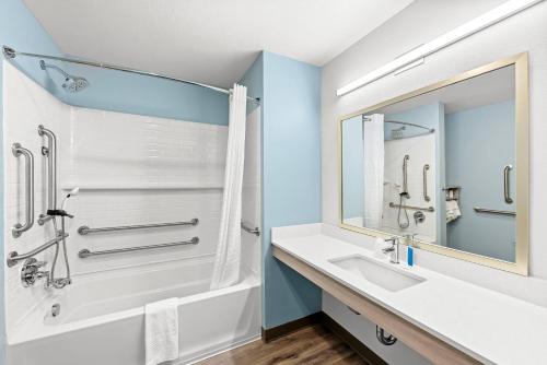 een badkamer met een witte wastafel en een douche bij WoodSpring Suites Oak Ridge Knoxville in Oak Ridge