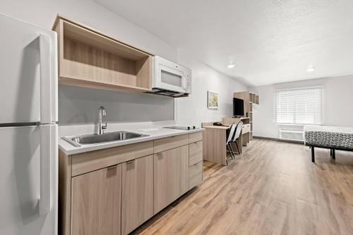 a kitchen with a sink and a white refrigerator at WoodSpring Suites Oak Ridge Knoxville in Oak Ridge