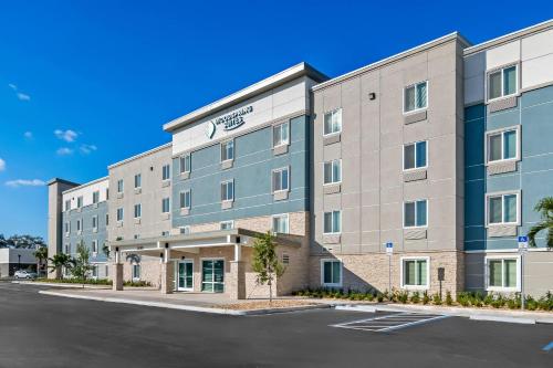 an image of the front of a hotel with a parking lot at WoodSpring Suites Palm Springs - West Palm Beach in Palm Springs