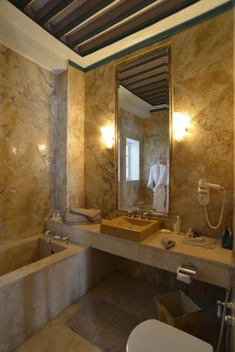 a bathroom with a tub and a sink and a mirror at Palais Bayram Tunis in Tunis