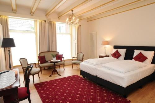 a bedroom with a large bed and a red rug at De Gulden Waagen in Nijmegen