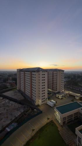 an aerial view of a building with a sunset in the background at Modern 1-Bedroom Apartment Near Kisumu CBD, Free WiFi, Parking & Security in Kisumu