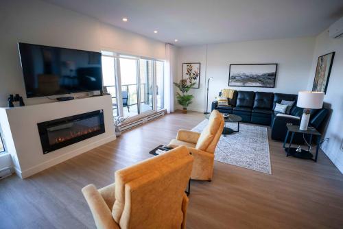 un salon avec un canapé et une cheminée dans l'établissement 302 - Full View - See Look Admire - Pool & Gym, à Baie-Saint-Paul