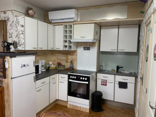 een keuken met witte kasten en een oven bij atelier couture in Reiningue