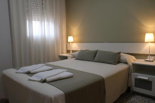 a bedroom with a bed with two pillows on it at Apartamentos Bolonia Paraiso in Bolonia