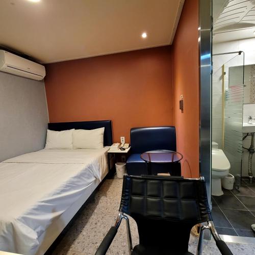 a bedroom with a bed and a table and a chair at 스카이모텔 in Seoul