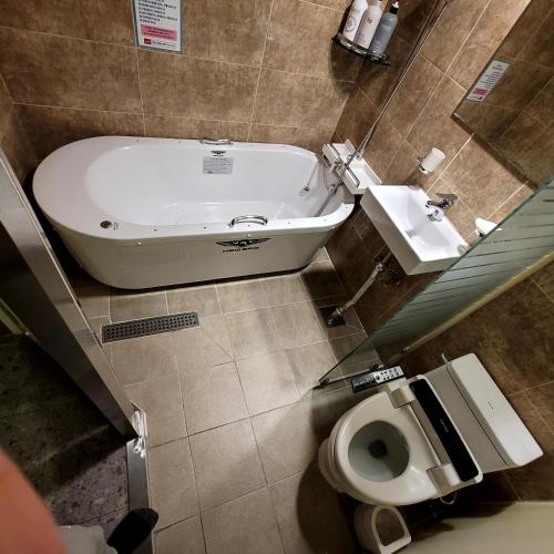 a bathroom with a tub and a toilet and a sink at 스카이모텔 in Seoul