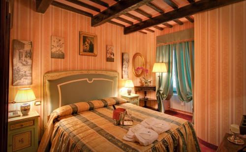 a bedroom with a bed with towels on it at Relais Antica Locanda La Diligenza in Borgo Pace