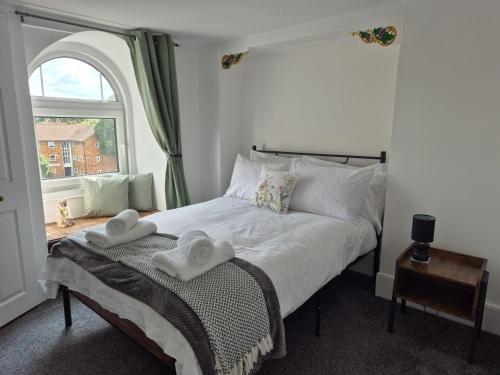 a bedroom with a bed with two towels on it at 2 Bed Maisonette with Sofa Bed - Ideal for Groups #26C in Portsmouth