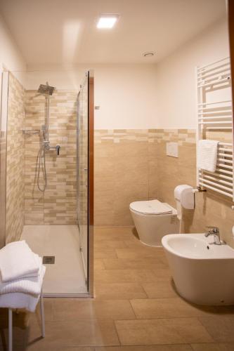 a bathroom with a shower and a toilet and a sink at Hotel Dimora Adriana in Tivoli