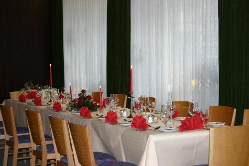a long table with red napkins and candles on it at Hotel Krone in Bad Münster am Stein-Ebernburg