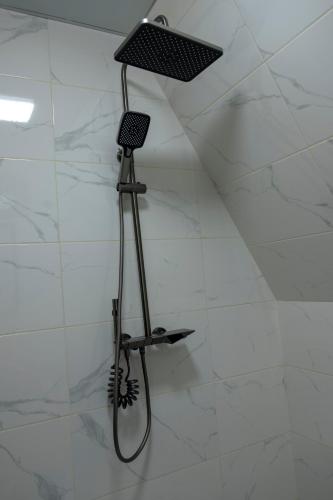 a shower with a shower head on a wall at Aurarest - აურარესთ in Makho