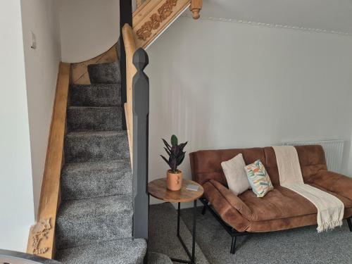 a living room with a couch and a staircase at 2 Bed Maisonette with Sofa Bed - Ideal for Groups #26C in Portsmouth