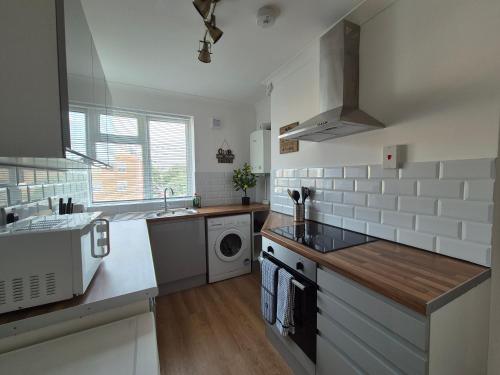 a kitchen with a sink and a washing machine at 2 Bed Maisonette with Sofa Bed - Ideal for Groups #26C in Portsmouth