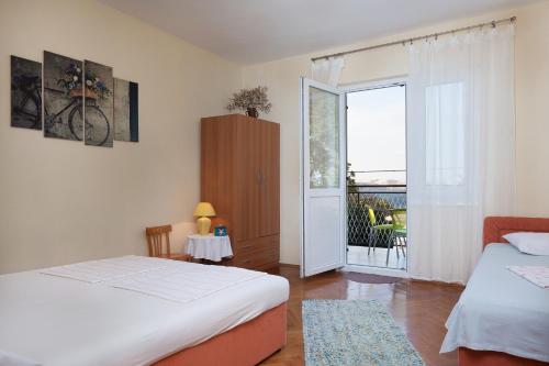 sypialnia z 2 łóżkami i przesuwnymi szklanymi drzwiami w obiekcie Apartman Davorka w mieście Karlobag
