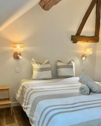 a bedroom with a large white bed with two pillows at La Cachette Vigneronne in Givry